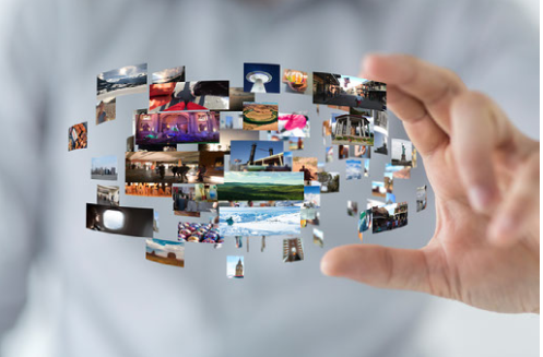 A spread of photographs fanning out from a hand